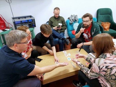 na zdjęciu osoby siedzące przy stolikach, grające w gry planszowe. Kliknij, aby powiększyć zdjęcie.